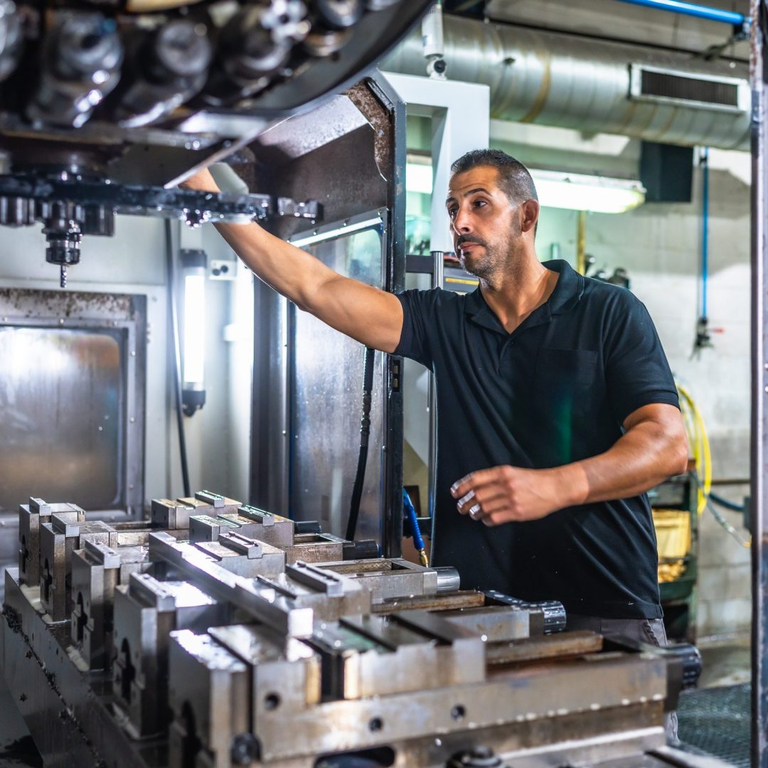 Male caucasian technician working with milling machine in a cnc metallurgic factory